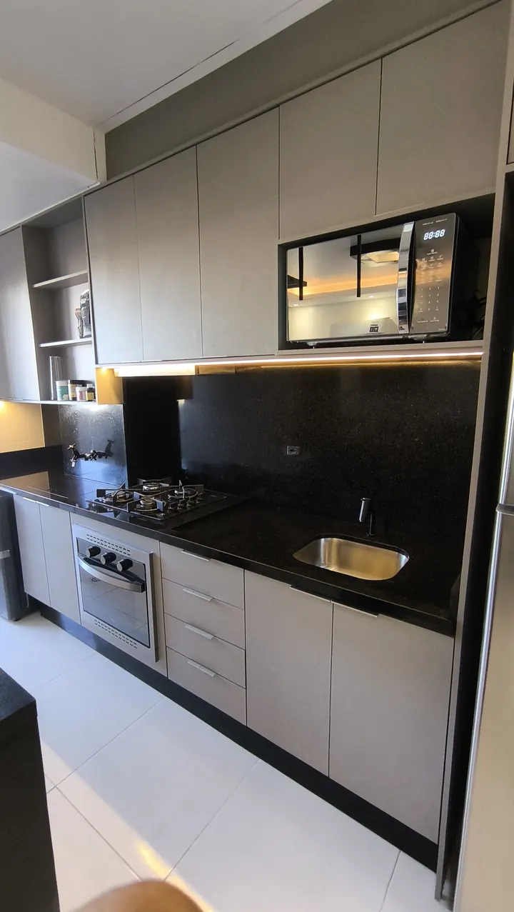 Cozinha com bancada e painel em pedra escura