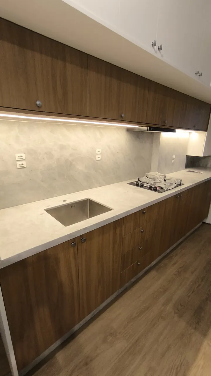 Bancada de cozinha em pedra cinza com painel e marcenaria em madeira